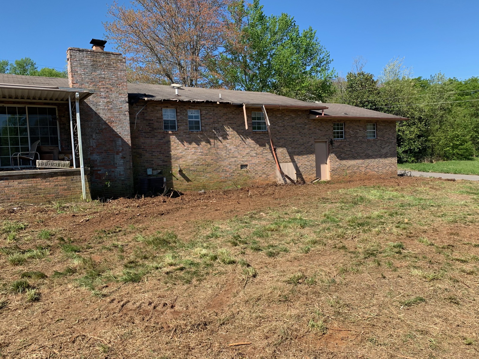 Same brick home after the yard has been cleared and graded — after