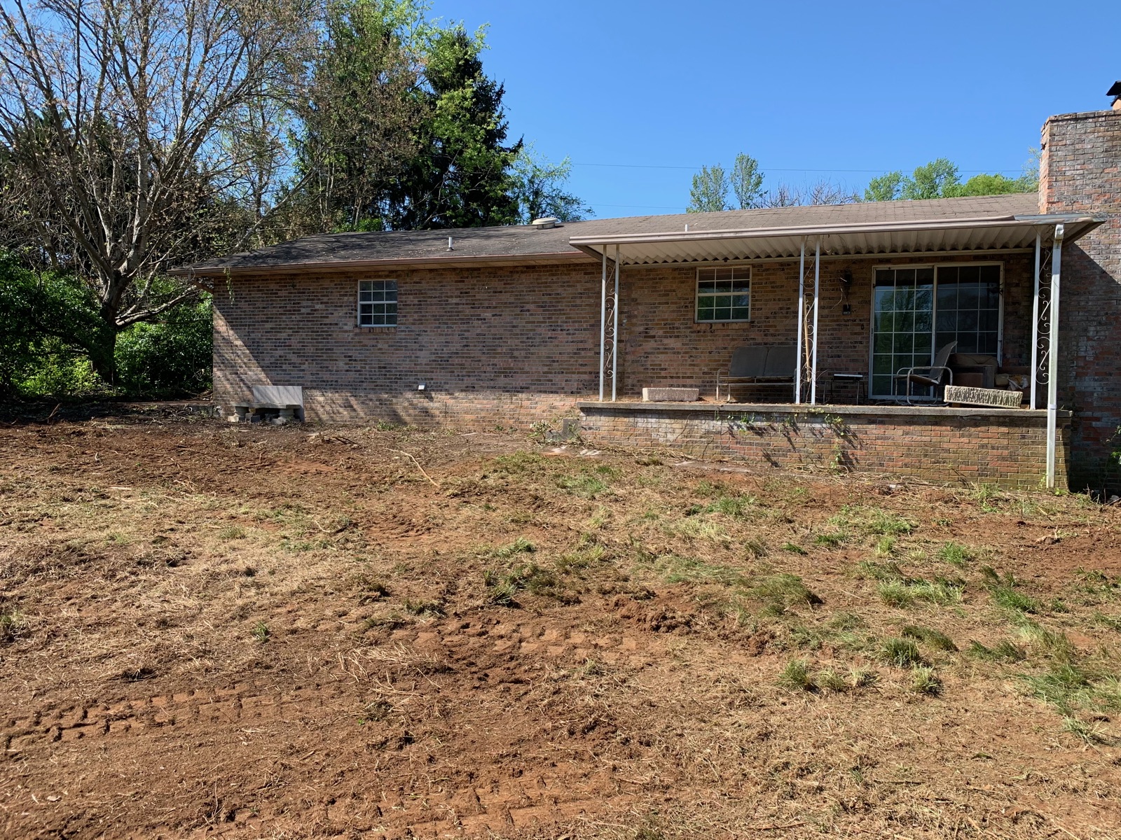 Brick home with overgrown yard fully cleared and cleaned up