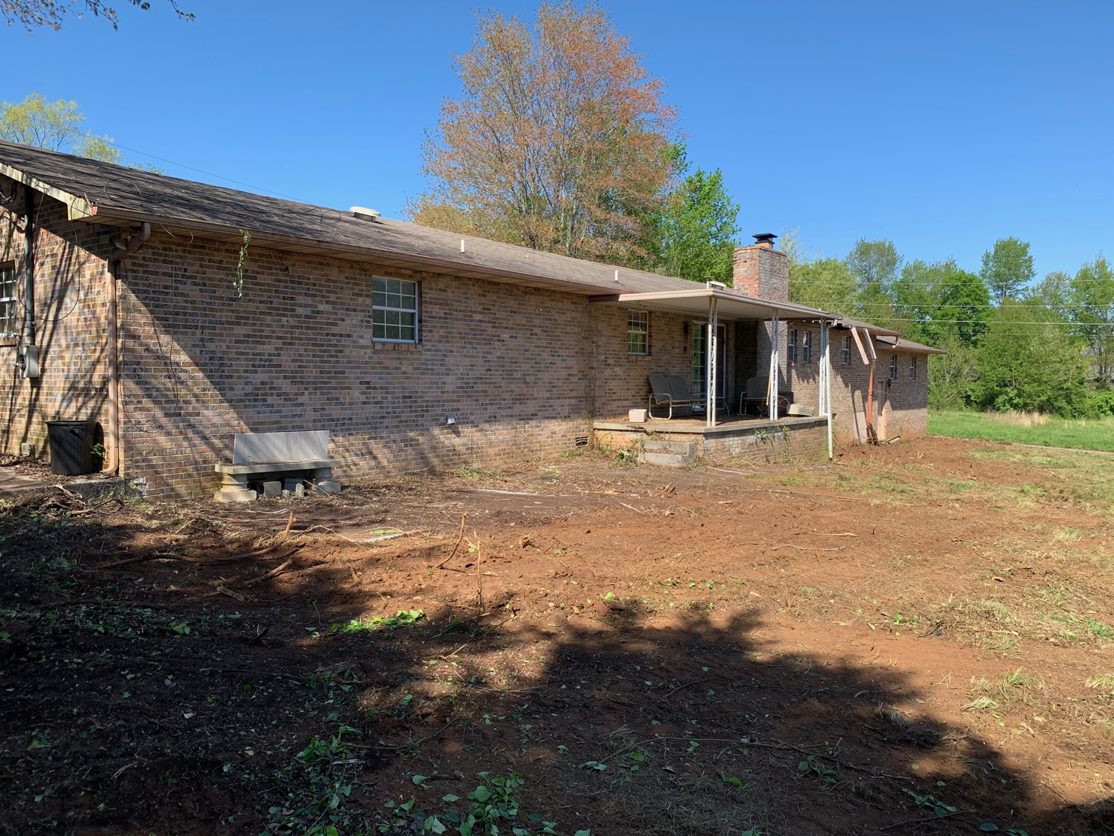Long brick ranch with yard fully cleared of brush and undergrowth