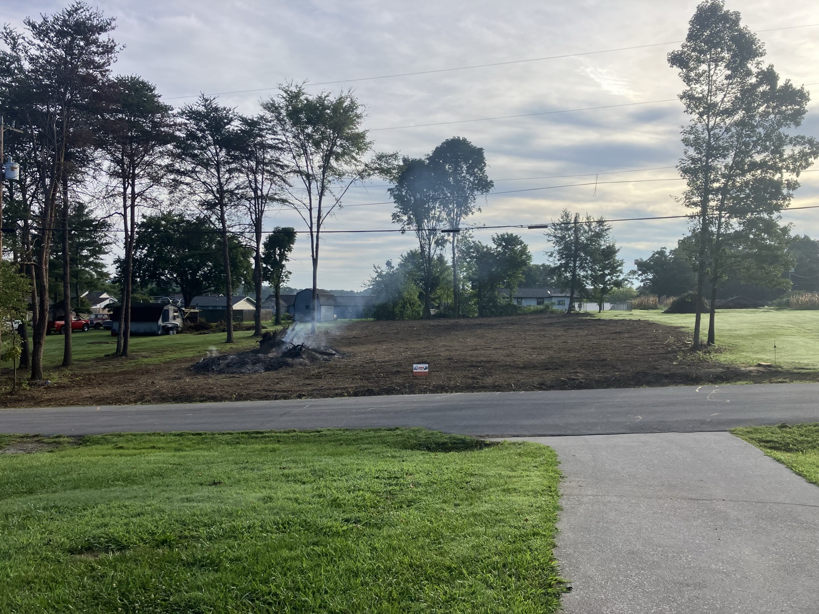 Cleared residential lot with cleanup in progress