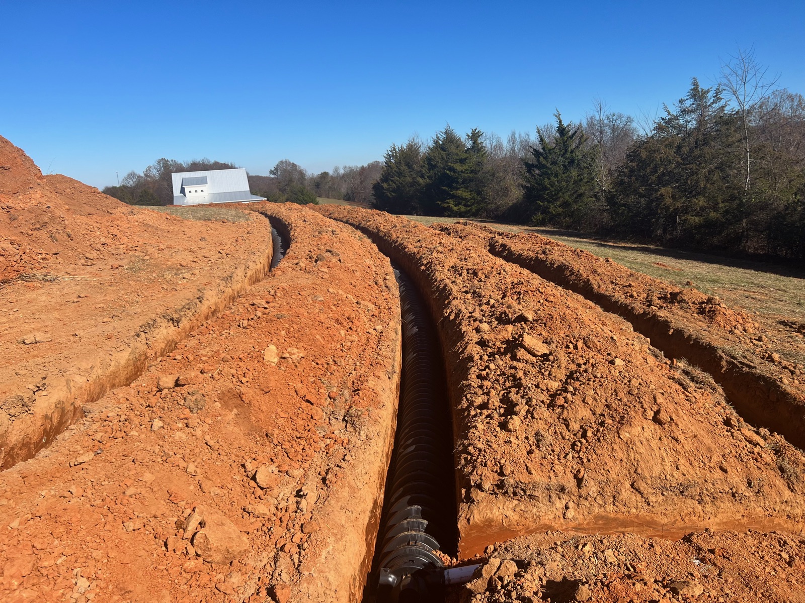 Septic field lines run through fresh trenches in winter