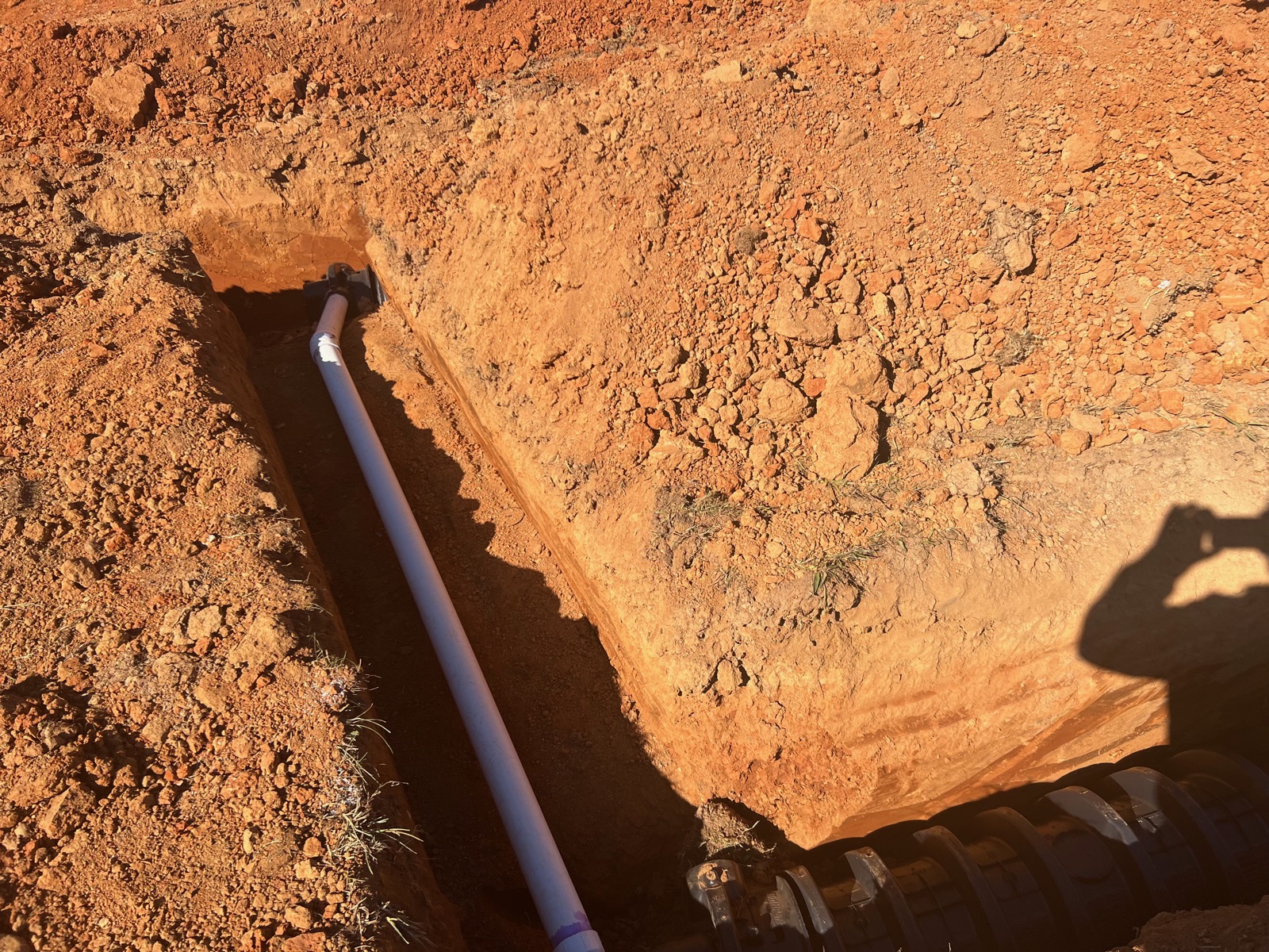 Septic line PVC plumbing detail in a freshly cut trench