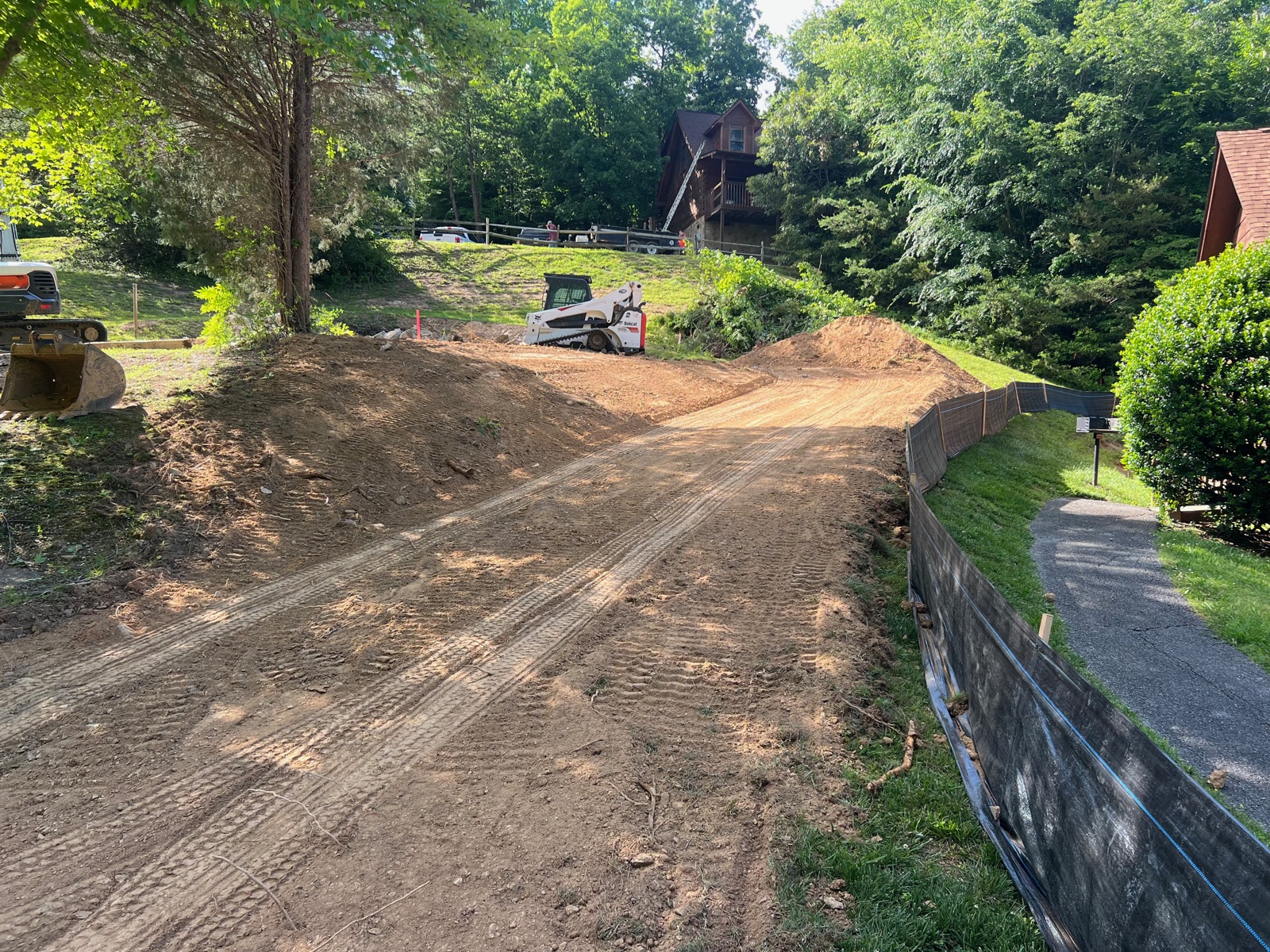 New residential driveway grade with skid steer working the cut