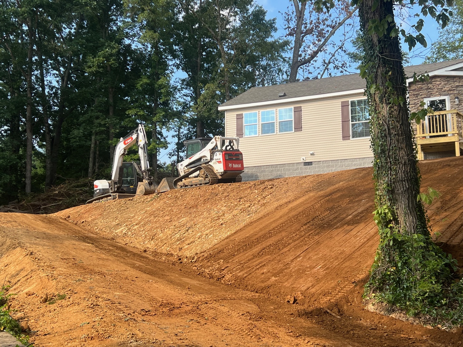 Fresh driveway grading and slope shaping at a new construction home