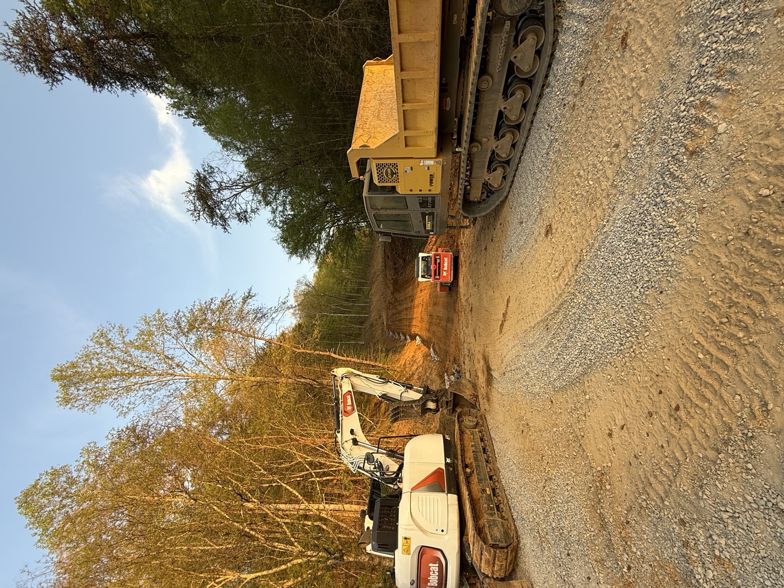 Dump truck and skid steer staged for driveway work