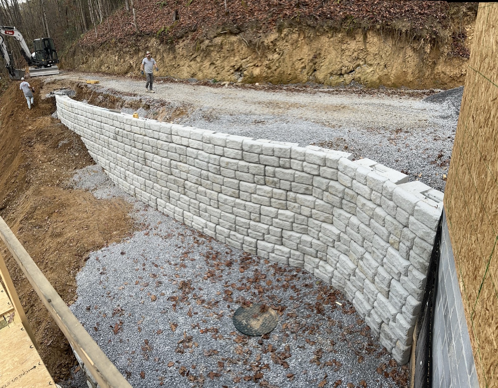 Block retaining wall under construction along a driveway