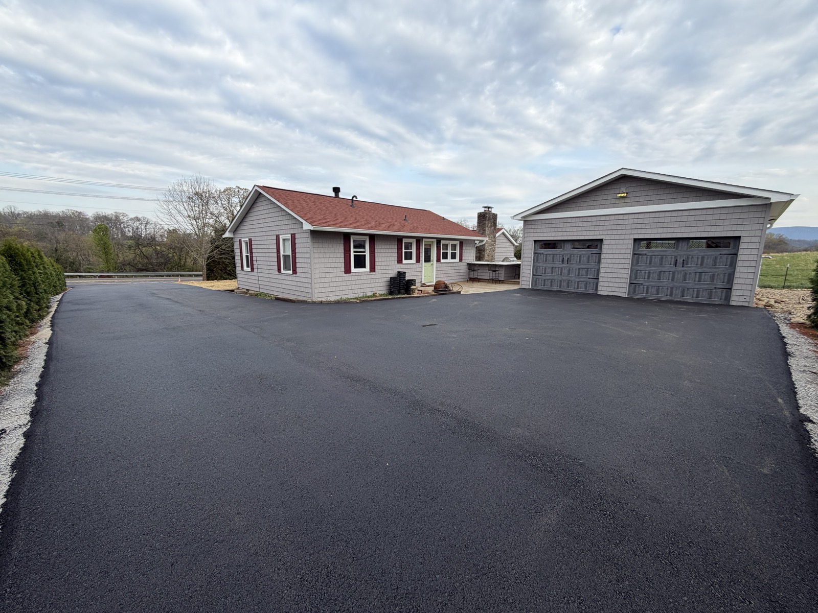 Finished asphalt driveway and turnaround at a house and detached garage